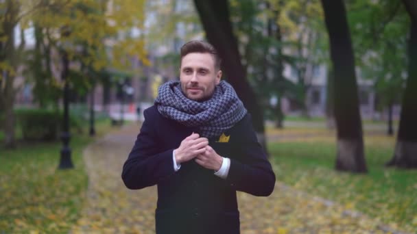 Un jeune homme vêtu d'un manteau sombre se glissant dans son attente dans le parc pour sa petite amie ou sa femme à un rendez-vous. Images 4k de haute qualité — Video