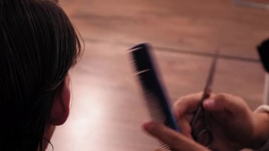 Yakın plan profesyonel kuaför kulaklarının arkasında saç kesiyor genç bir adama şık bir saç kesimi yapıyor. Yüksek kaliteli 4k çözünürlük görüntüleri