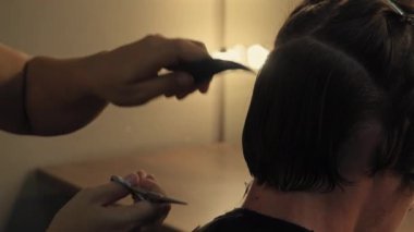 Arka plan kuaför kadın uzuvları, bölüm erkekleri, kafasının arkasından, saçlarını yoluyorlar, yarı aydınlık odada saçlarını kesiyorlar. Yüksek kaliteli 4k çözünürlük görüntüleri