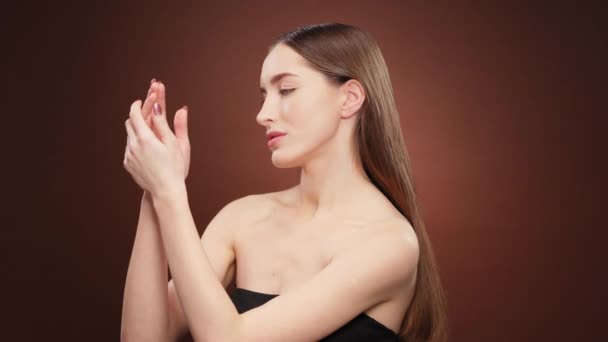 Piękny model dziewczyna nawilżające ręce z kremem lub leczenia, idealna skóra długie piękne długie włosy z gołymi ramionami. Piękno i pielęgnacja skóry. Kosmetologia. Materiał 4K — Wideo stockowe