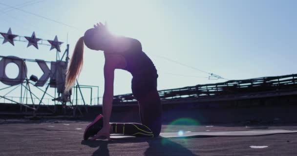 Genç atlet kadın binanın çatısında yoga esneme egzersizi yapıyor. Çifte konsept. Yüksek kalite 4k görüntü — Stok video