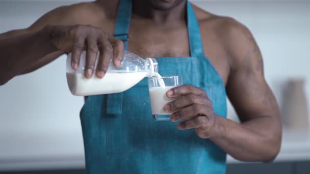 Een persoon in blauwe rug spettert met een glas melk op een witte achtergrond. Hoge kwaliteit beeldmateriaal — Stockvideo