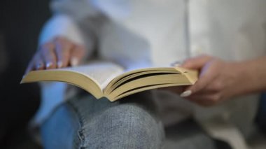 Kitap okuma konsepti. Diz üstü Metin Okunuyor, Yakın plan. Dizlerimin üzerinde kitabı aç. Dizlerinin üstünde kitap okumak, güzel kadınların elleri dizlerinin üzerinde kitap tutmak. Yüksek Kalite 4K Görüntü