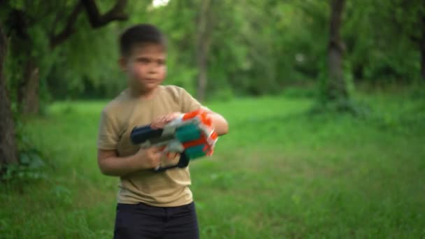 Dítě drží hračku a střílí náboje. Červen 2020. Kyjev, Ukrajina. — Stock video