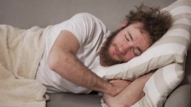 Uyan! Uyan! Adam kız arkadaşına yastık fırlatıyor. Adam suçluydu, kanepede yatıyordu. Yüksek kalite 4k görüntü