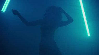 Partide neonlar içinde dans eden güzel bir kız. Yüksek kaliteli FullHD görüntüler