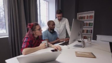 Modern ofis açılışında yaratıcı iş ekibi toplantısı ekranı işaret ediyor. İş stratejilerinin geliştirilmesi, planlar.