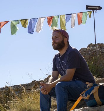 Budist bayraklarıyla dağda bir adam