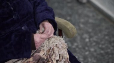 Alzheimer 'lı yaşlı kadın bir ipliği çözmeye çalışıyor.