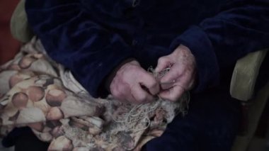 Alzheimer 'lı yaşlı kadın bir ipliği çözmeye çalışıyor.