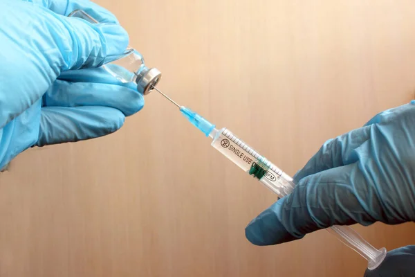 Laboratuvardaki doktor ya da bilim adamı Coronavirus virüsünü kontrol etme kavramı, çocuklar ya da yaşlılar için sıvı aşı içeren bir şırınga taşıyor: hastalık, tıbbi bakım, bilim