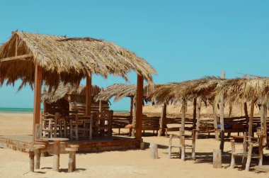 Plajda güneşli yataklar, Mısır. Sarı kum, mavi gökyüzü. Tatil yeri, dinlenme.