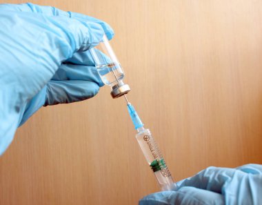 Laboratuvardaki doktor ya da bilim adamı Coronavirus virüsünü kontrol etme kavramı, çocuklar ya da yaşlılar için sıvı aşı içeren bir şırınga taşıyor: hastalık, tıbbi bakım, bilim