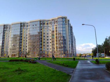 Camdan balkonları olan yeni, modern bir apartman. Konut alanı. Asfalt kaldırımlı bir yaya yolu eve çıkıyor. Emlakçılık. Boşluğu kopyala