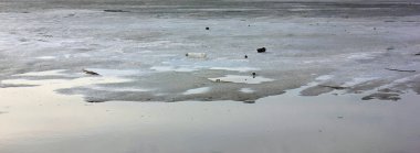 Buz gölde eriyor. Buz, suda bir sürü küçük buz. Bahar geliyor. Doğanın Uyanışı. Pankart. Panorama