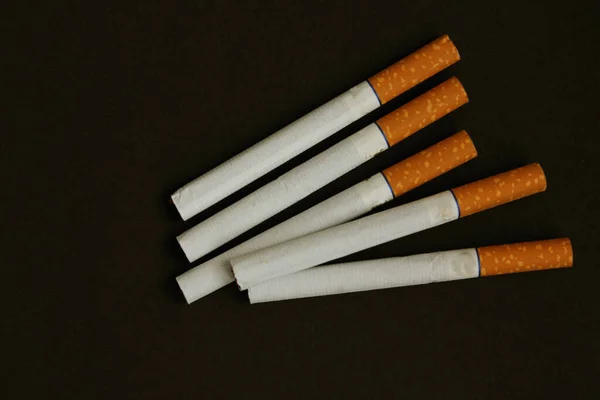 Viele Zigaretten auf schwarzem Hintergrund. Das Konzept von World No Tobacco, Tobacco and Lung Health. Kopierraum. Gesundheitsschädlich. Es ist eine schlechte Angewohnheit. Blick von oben. Zigaretten mit Gelbfilter sind ganz. — Stockfoto