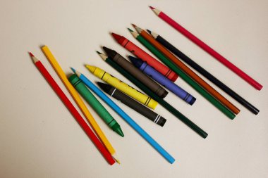 Beyaz arka planda renkli kalemler. Bir sürü farklı renkli balmumu kalem. Renkli kalem. Çizim dersleri, hobiler, eğitim, yaratıcılık. Yakın plan. Uzayı kopyala Geçmişi. Düz yatıyordu