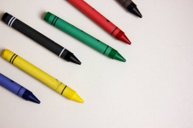 Beyaz arka planda renkli kalemler. Bir sürü farklı renkli balmumu kalem. Renkli kalem. Kalemler solda. Çizim dersleri, hobiler, eğitim, yaratıcılık. Uzayı kopyala Geçmişi. Düz yatıyordu