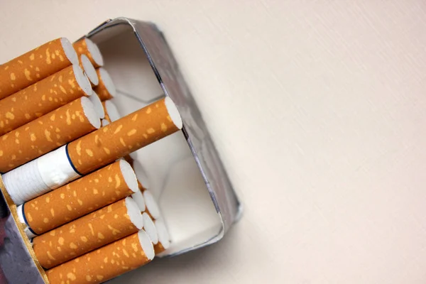 A pack of cigarettes on a white background. open pack of cigarettes. Yellow filter. Harm to health. It is a bad habit. The concept of World No Tobacco, Tobacco and Lung Health. Cigarettes in a tutu