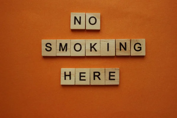 Orden Rökning förbjuden här på bakgrunden. Ord gjorda av träkuber. Rökning är förbjuden, förbjudna skyltar i offentliga byggnader, korridorer, rum, allmänna platser, vägar, trottoarer. Utsikt ovanifrån — Stockfoto