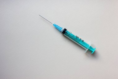 Işık arka planında iğne olan bir şırınga. Aşı. İlaç ve bağışıklık kavramı. Virüs enfeksiyonlarına karşı aşı. İlaç ve iğne. Soğuk. Enjeksiyon, ilaç. Uzayı kopyala Düzgünce