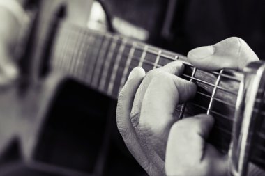 Gitar çalma alıştırması, Gitar çalan genç erkeklerin eli