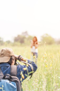 Yeşil alanda karşı genç güzel kadın fotoğraflama Adam bir