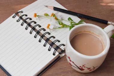 Bir fincan sıcak kahve, çiçekler ve kitap, romantik arka plan 