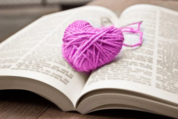 Kötés, gyapjú fektetni a könyv rózsaszín szív — Stock Fotó