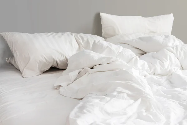 Bed and white pillows with wrinkle blanket in bedroom, from slee — Stock Photo, Image