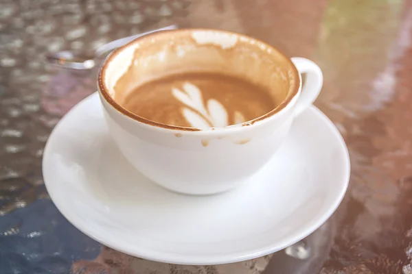 Taza blanca de café con leche, medio bebido en la taza ya ha sido en — Foto de Stock