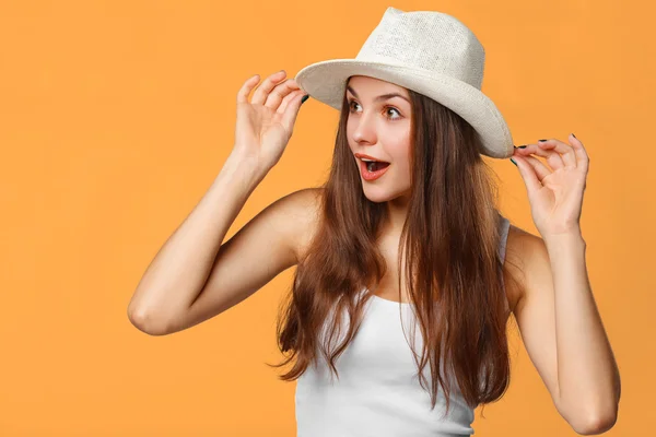 Surpreendida mulher feliz olhando de lado na emoção. Isolado sobre fundo laranja — Fotografia de Stock