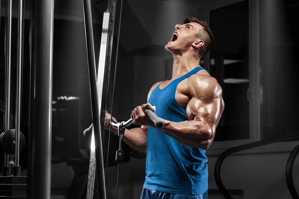 Muscular man working out in gym doing exercises at biceps, strong male — Stock Photo, Image