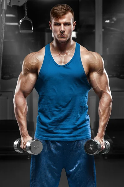 Hombre musculoso haciendo ejercicio en el gimnasio haciendo ejercicios con pesas, fuerte torso masculino —  Fotos de Stock