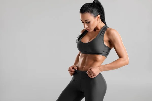 Fitness Vrouw Met Buikspieren Platte Buik Grijze Achtergrond Mooi Atletisch — Stockfoto