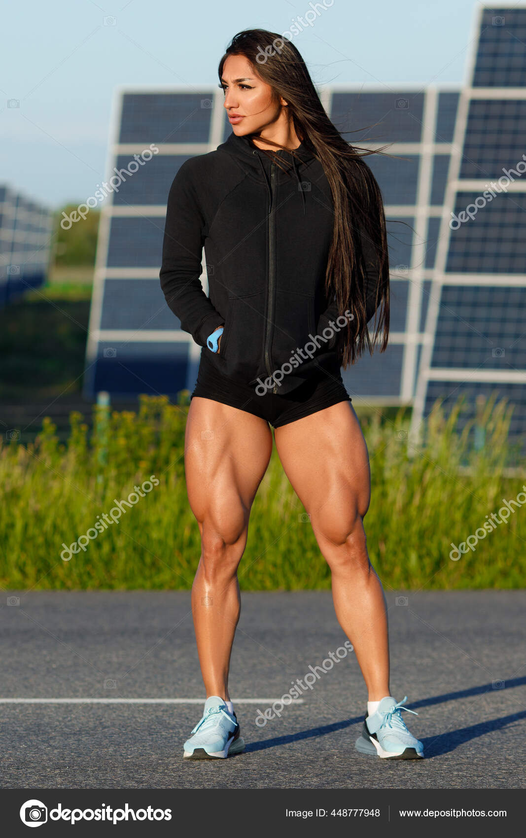 Beautiful athletic woman with long hair working out with dumbbells