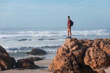 Sırt çantalı gezgin, okyanus manzaralı, gün batımında yürüyüş, seyahat konsepti, Kaliforniya, ABD