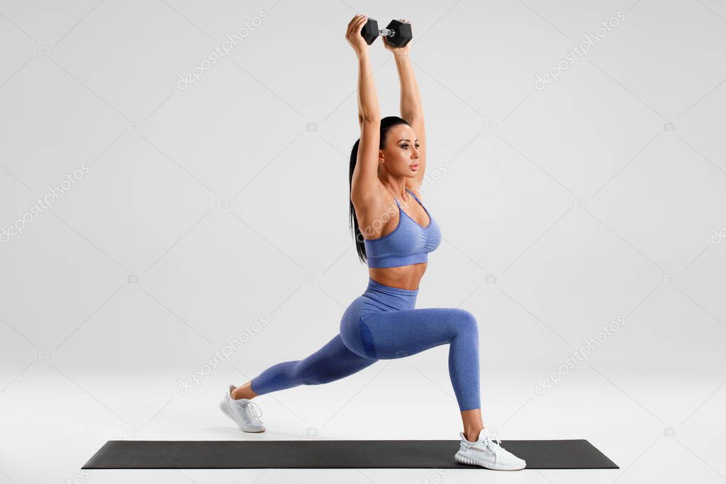Fitness woman doing lunges exercises with dumbbell, leg muscle training. Active girl doing front forward one leg step lunge