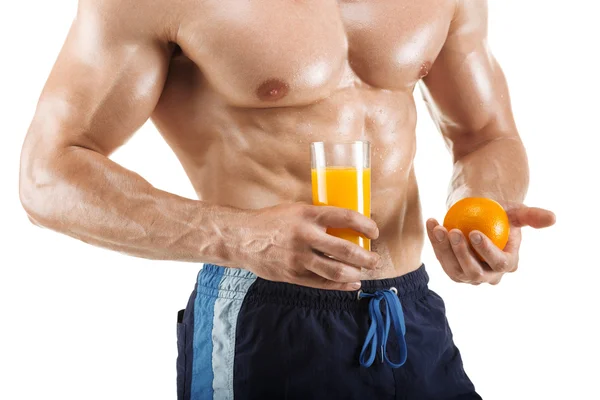Healthy muscular man holding a glass with juice and orange, shaped abdominal, isolated on white background — Stock Photo, Image