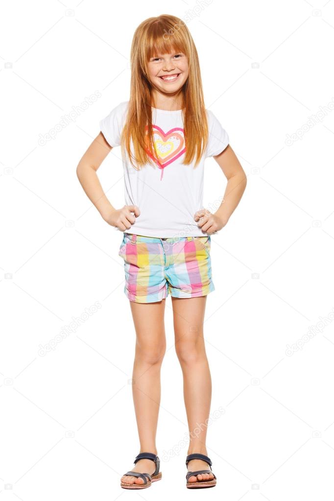 Full length a cheerful little girl with red hair in shorts and a T-shirt, isolated on the white background