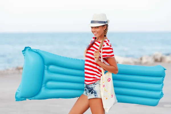 Woman with blue mattress at the beach — Stock Photo, Image