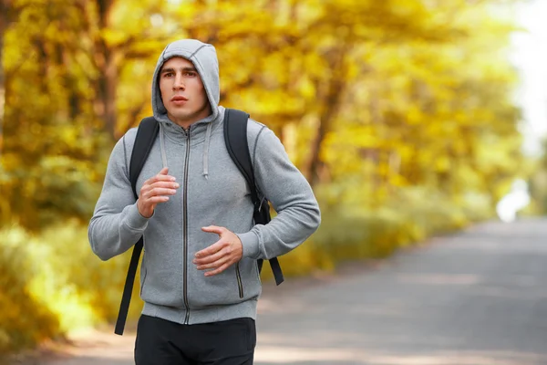Hombre corredor corriendo en el camino de otoño entrenamiento sprint. Deportivo masculino corriendo ejercitándose, afuera — Foto de Stock