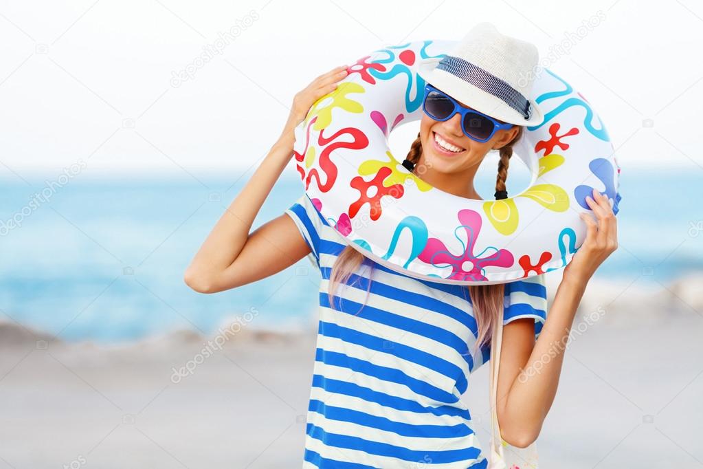 Beach woman happy and colorful wearing sunglasses and beach hat having summer fun during travel holidays vacation