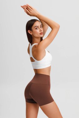 Gri arka plandaki atletik kız. Fitness kadını