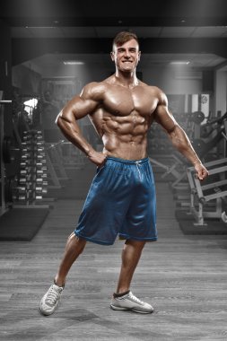 Spor salonunda, poz seksi kaslı adam karın şeklinde. Güçlü erkek çıplak gövde abs, çalışma dışarı