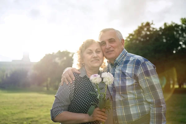 Happy senior couple walking in the park at sunset