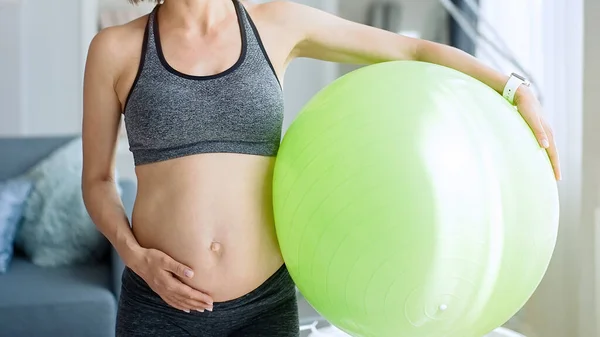 Schwangere Trainiert Hause Auf Fitball lizenzfreie Stockfotos
