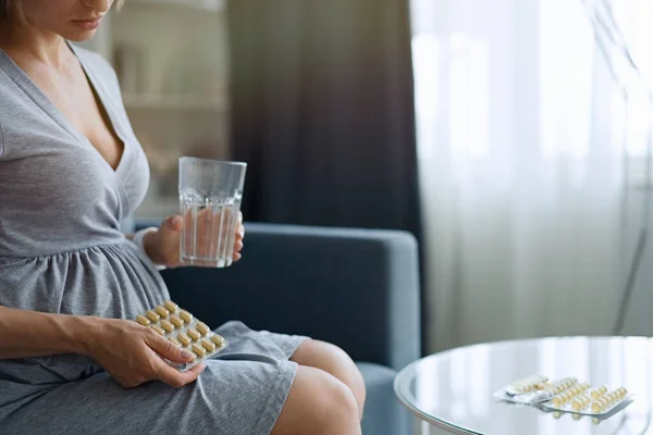 Junge Schwangere Frau Nimmt Medikamente Und Trinkt Wasser Stockbild