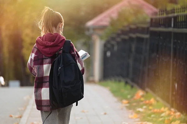 可爱的少女背着背包上学 学生和教育 年轻人在学校 背景色 图库图片