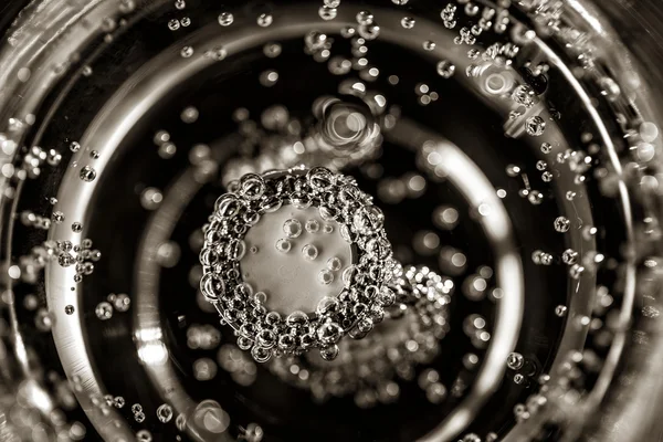 Cufflinks in a glass of champagne. — Stock Photo, Image